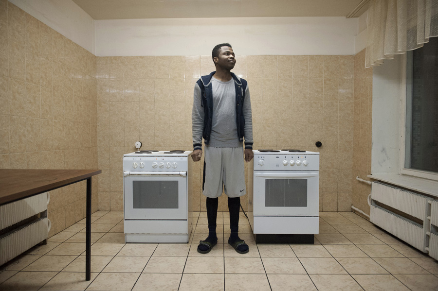 Issac Ismaila, a student from Nigeria, between the two stoves of the floor’s communal kitchen.
